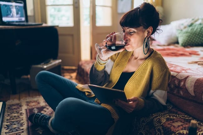 woman with wine watching movie on tablet.width .jpg