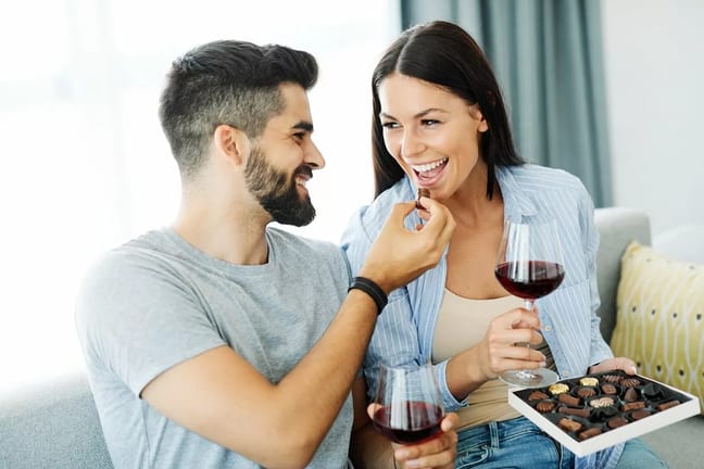 Couple eating chocolates and drinking wine to.width .jpg