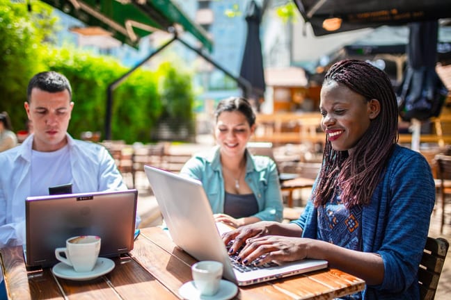 Three adults sitting on a patio utilizing the.width AYTguO.jpg