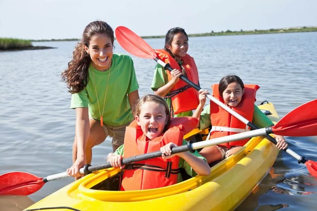 Young adult girl helping kids in a kayak FaRw.width .jpg