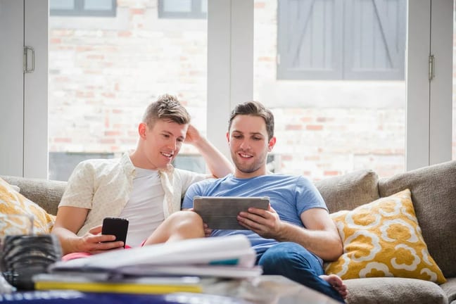 Young couple sit on sofa and look at tablet .width .jpg