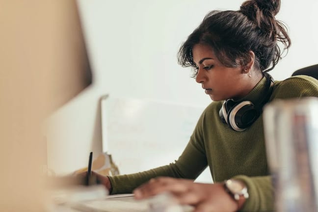 Young woman writing with headphones rJQSmvR.width .jpg