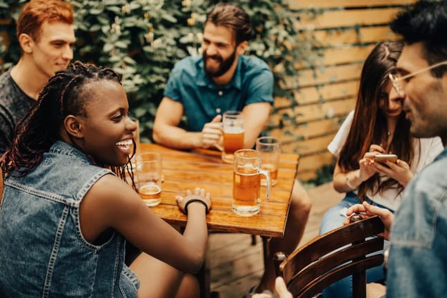 friends drinking beers at patio table WwKdweZ.width .jpg