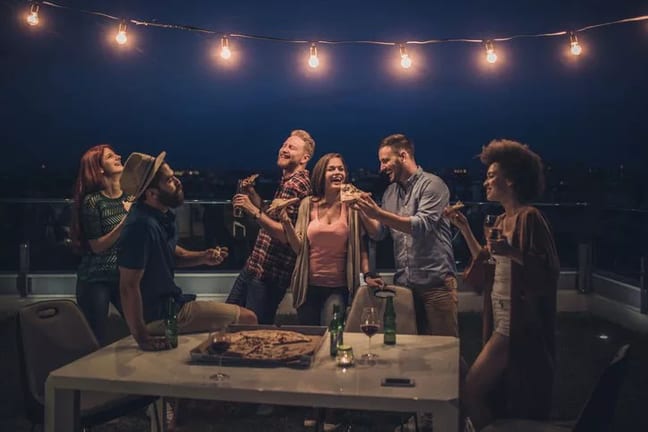 friends eating pizza and beer at rooftop part.width pMowu.jpg