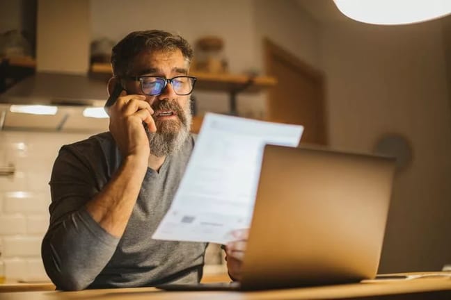 man on phone with paper and laptop KarxXs.width .jpg