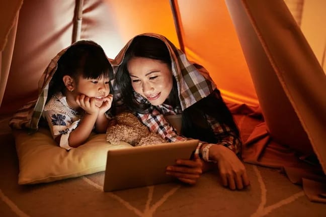 mom and young daughter watching movie on tabl.width .jpg