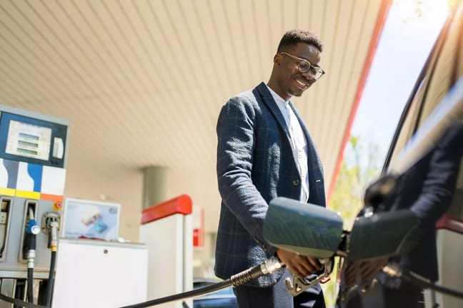 person filing up their car with gas AhVsk.width .jpg