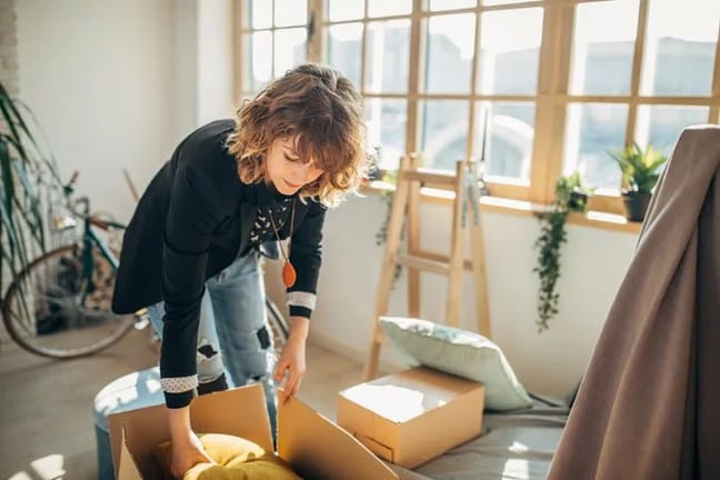woman packing moving boxes in apartment Pedi.width .jpg