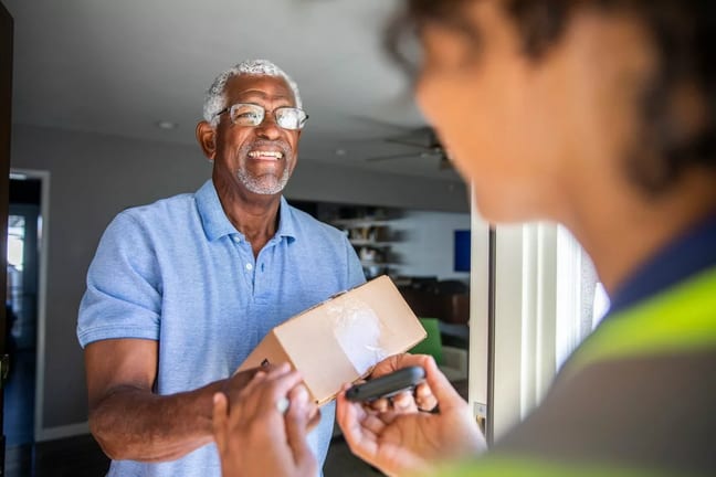 Man accepting package from a delivery driver .width .jpg