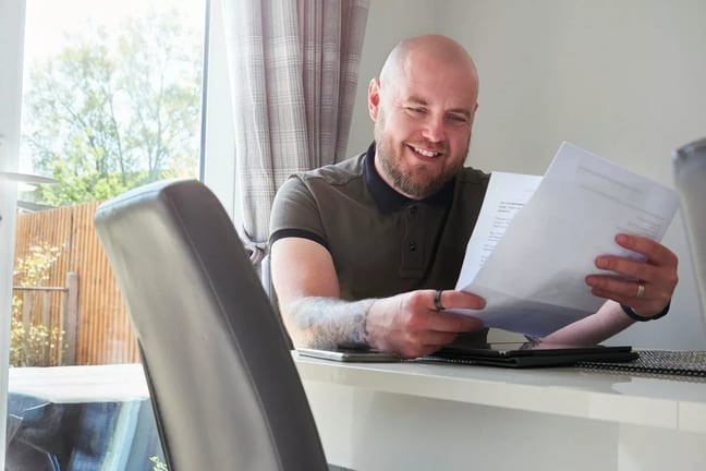 Man smiling reading a letter rvqbJE.width .jpg