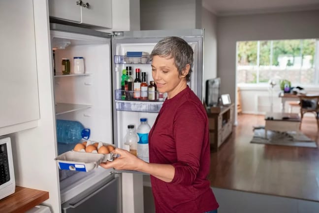 Woman opening refrigerator ymOwHf.width .jpg