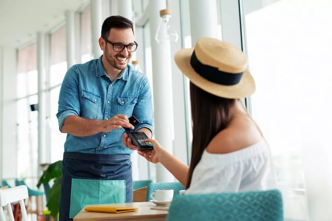 Woman paying waiter credit card KqTSHc.width .jpg