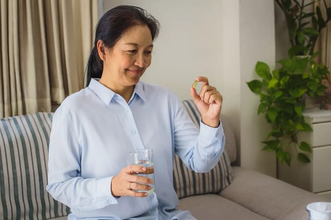 asian woman holding a pill.jpg