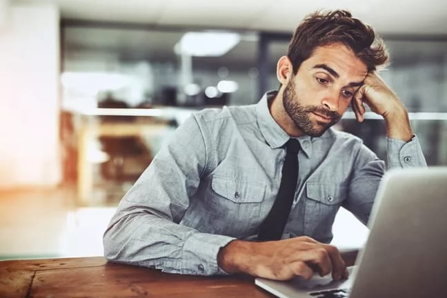 bored man working at computer at office job.width .jpg