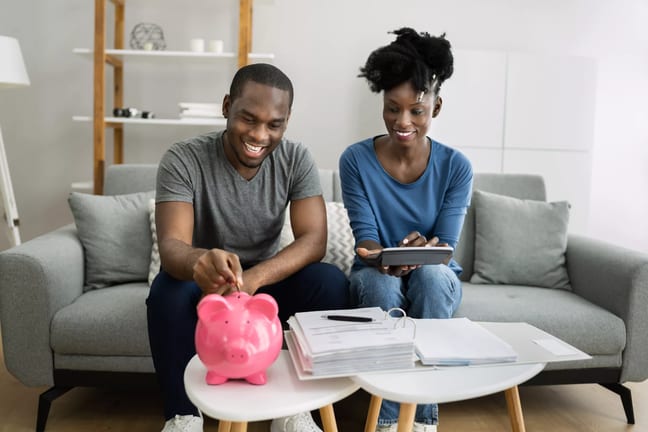 couple saving money in pink piggy bank.jpg