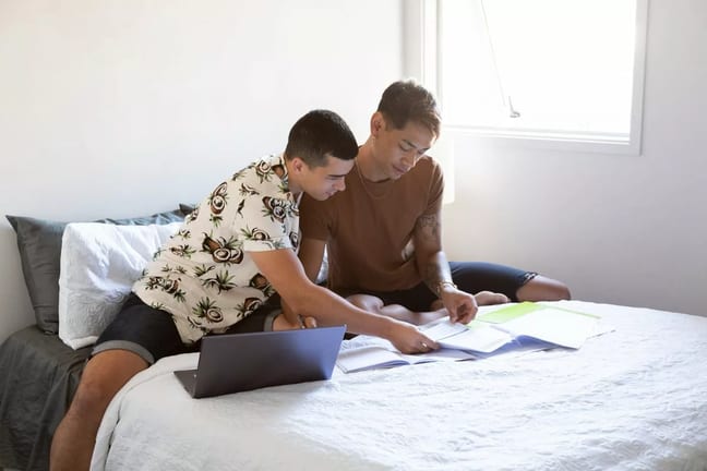 two people sitting on bed with paperwork and .width AejXpPB.jpg
