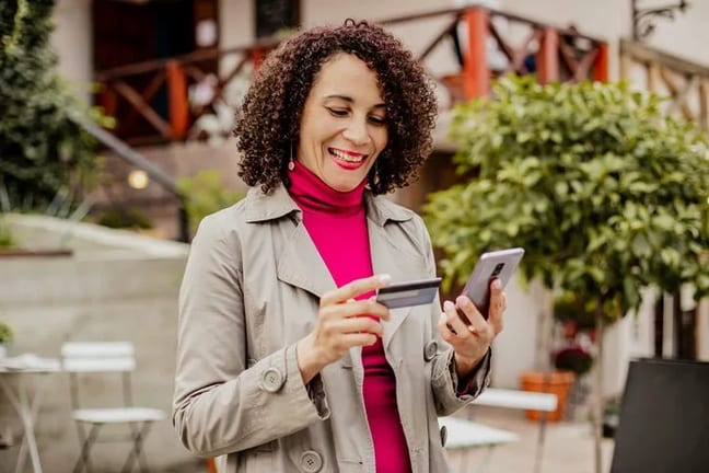 woman holding credit card and phone vpiLZ.width .jpg