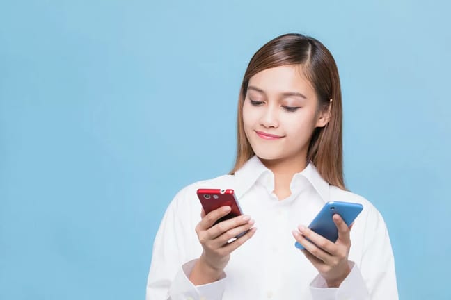 woman looking at red phone and blue phone AyA.width .jpg