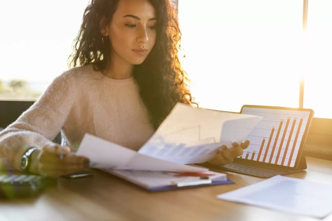 young woman sitting at a desk looking at charts.jpg