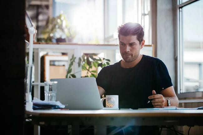 young man sitting at desk using laptop and th.width rNXRoV.jpg