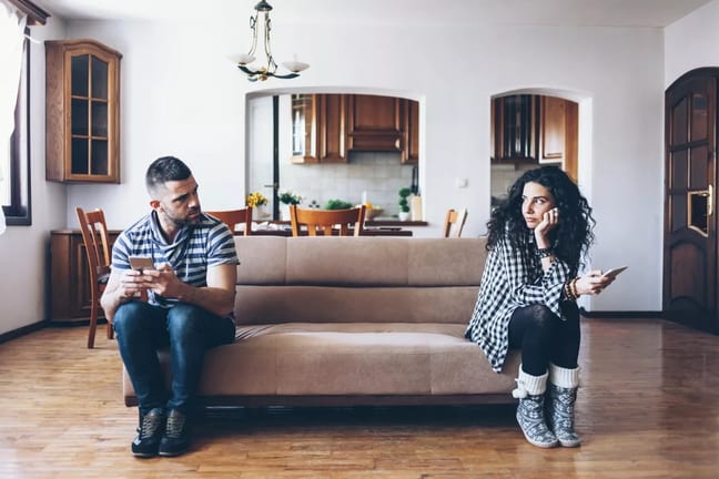 man and woman sitting at opposite ends of a c.width lniJNV.jpg
