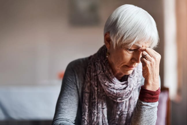 older woman pinching top of nose gettyimages .jpg