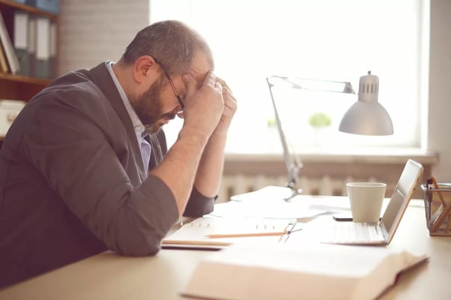 stressed man working at desk kJlAx.width .jpg