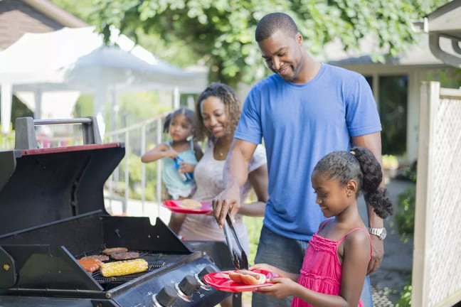 Family grilling hamburgers hotdogs and corn i.width .jpg