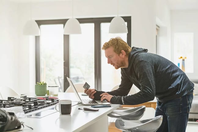 Man holding credit card and using laptop Hlq.width .jpg