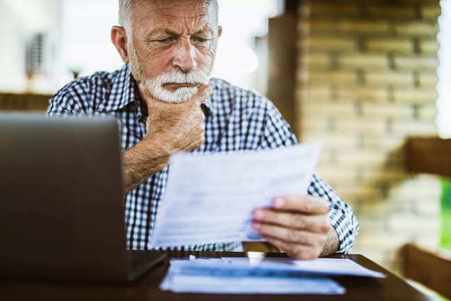 older man serious looking at document gettyimages .jpg