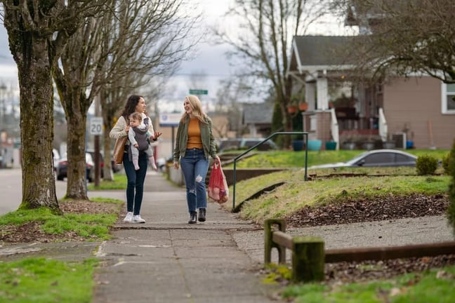 two people and baby walk down residential str.width lGpivdf.jpg