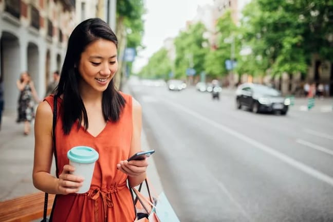 woman on street with phone and coffee.width .jpg
