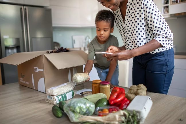mother and son opening meal service kit.width .jpg