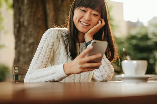 smiling person using smartphone TFngkG.width .jpg