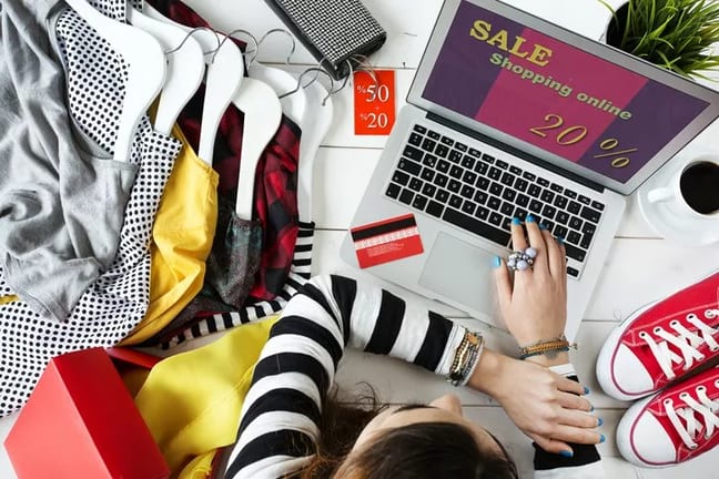 woman online shopping on laptop with clothes .width .jpg
