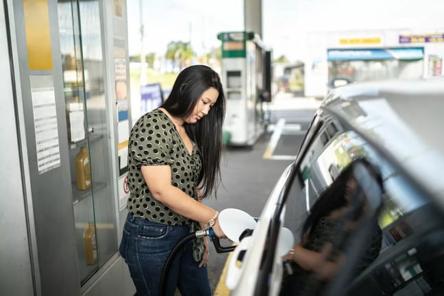Woman refueling her car at a gas station tn.width .jpg