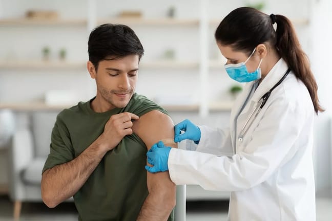 Healthcare worker putting bandaid over vaccin.width .jpg