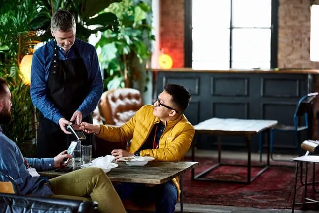 man paying in restaurant with credit card BH.width .jpg