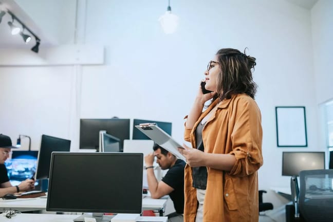 Woman in office holding clipboard and talking.width imFW.jpg