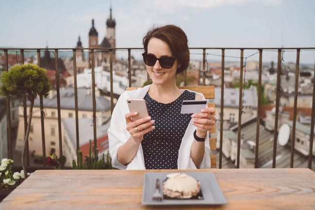Woman holding her credit card and smiling whi.width iMSYz.jpg