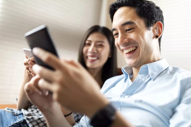 getty couple smiling at phone happy success.jpg