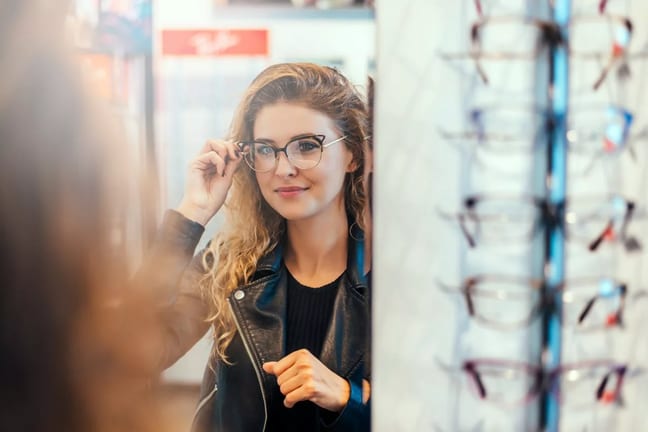 Smiling young woman trying on eyeglasses. dg.width .jpg
