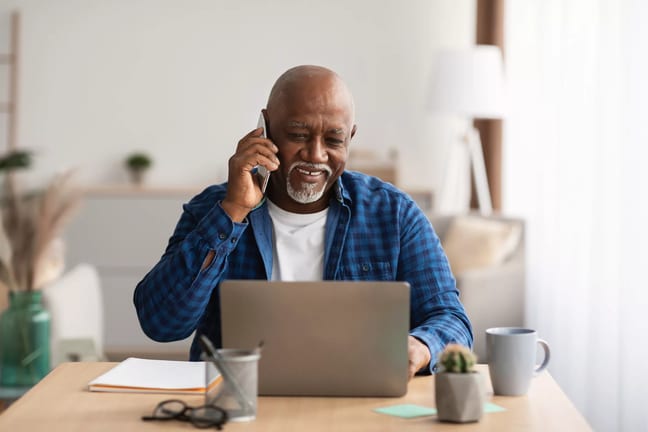 person talking on the phone and looking at a laptop.jpg