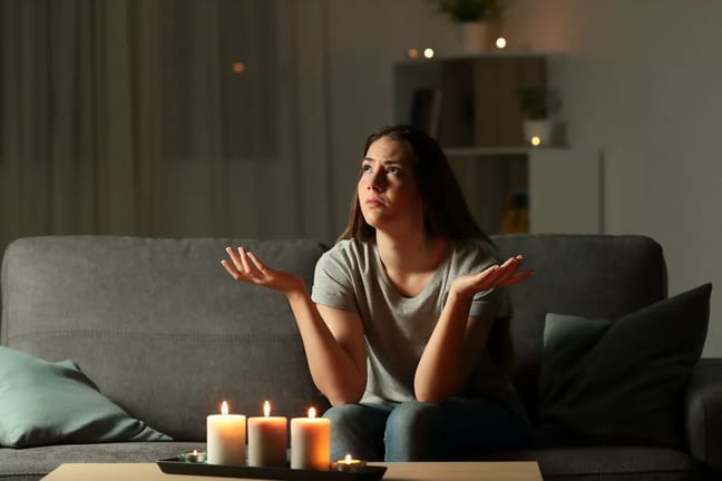 person on couch with candles on coffee table .width .jpg