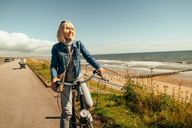 smiling person riding on bicycle by the ocean.jpg