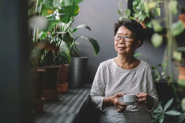 woman drinking tea near houseplants rpwlRul.width .jpg