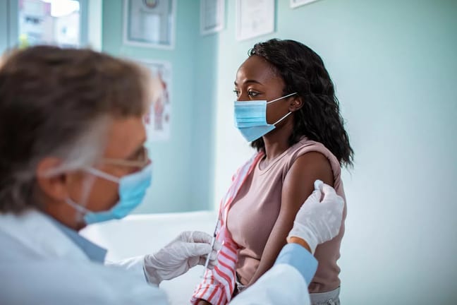 Masked woman receiving injection in her arm A.width .jpg