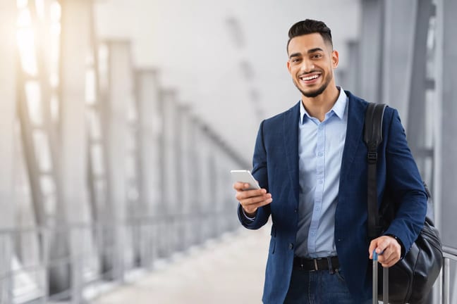 getty business traveler with shoulder bag smiling happy.jpg