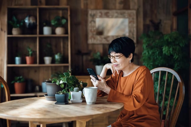 person sitting at a table using a smartphone.jpg