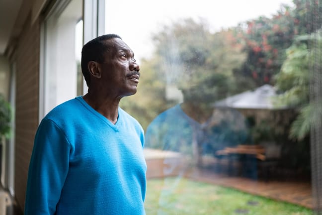 person with serious expression looking out a window.jpg